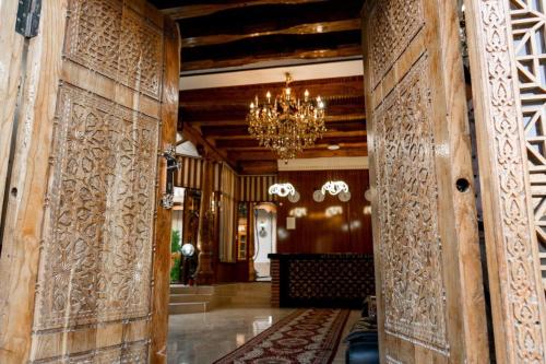 un pasillo con paredes de madera y una lámpara de araña en Grand Nodirbek Boutique Hotel, en Bukhara