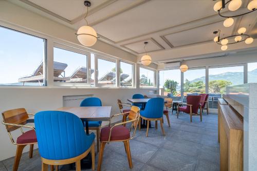 a restaurant with tables and chairs and windows at Elysium Tivat in Tivat