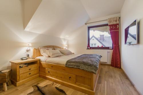 een slaapkamer met een groot bed en een raam bij Apartament Montagne in Zakopane