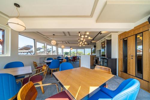 a dining room with tables and blue chairs at Elysium Tivat in Tivat