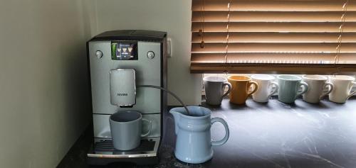a row of coffee cups and a coffee machine at Elly House in Haapsalu