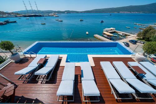a swimming pool on a deck with a view of the water at Elysium Tivat in Tivat