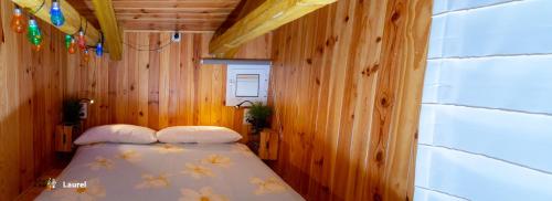 マラガにあるLa Casa del Druidaの木製の部屋にベッド1台が備わるベッドルーム1室があります。