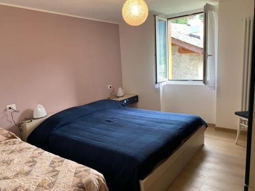 a bedroom with a bed with a blue blanket on it at Da Giulia e Pietro Antonio in Pianazzo