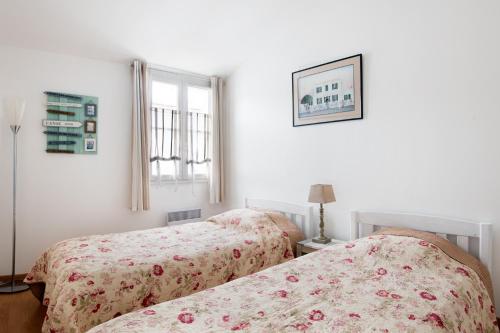 Dos camas una al lado de la otra en un dormitorio. en Maison Telline, en Saint-Martin-de-Ré