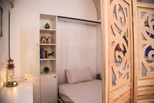 um quarto com uma cama e uma estante de livros em Casa del sole em Ceglie Messapica