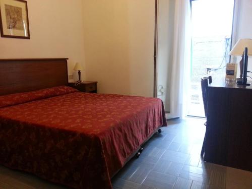 a bedroom with a bed and a dresser at Hotel Isola Bella in Taormina