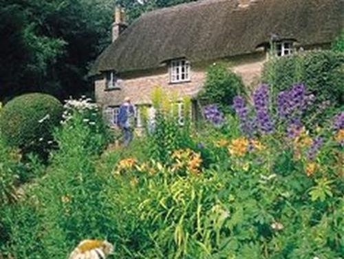 una casa con un jardín de flores delante de ella en Bramlies Bed & Breakfast, en Dorchester