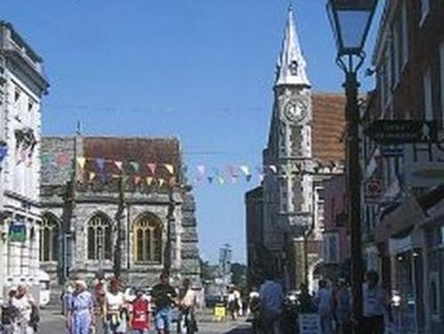 una concurrida calle de la ciudad con una torre de reloj en un edificio en Bramlies Bed & Breakfast en Dorchester