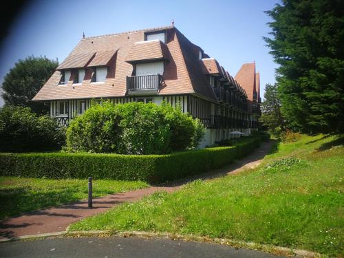 a large house on a hill with a road at Joli studio neuf vue mer proche Deauville in Blonville-sur-Mer