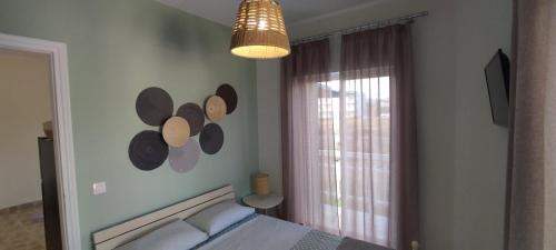 a bedroom with a bed and a lamp and a window at Harmony House Marathopoli 1 in Marathopoli