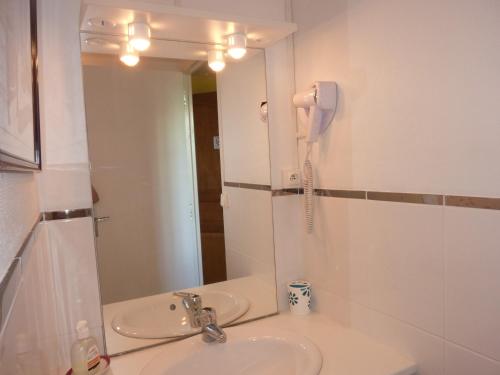 a bathroom with a sink and a phone in a mirror at Chambre d'hôtes Au Fil De L'eau in Jumièges