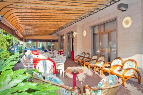 un grupo de sillas y mesas en un patio en Hotel Catto Suisse en Caorle