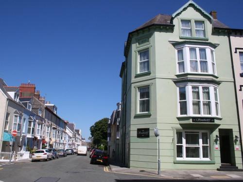 a green building on the side of a street at Southcliff Guest House in Tenby