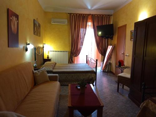ein Wohnzimmer mit einem Sofa und einem Bett in einem Zimmer in der Unterkunft Palazzo Aprile in Caltagirone