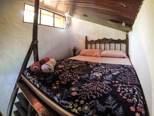 a bed in a small room with a blanket on it at Ready Camp e Suítes da Cachoeira in Abraão