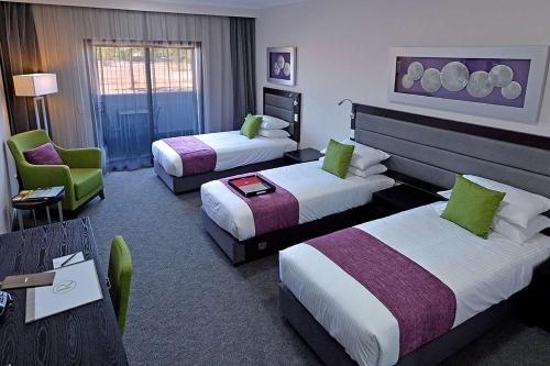 A bed or beds in a room at Rydges Palmerston - Darwin