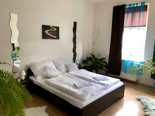 a bedroom with a bed with white sheets and a window at Beauty-Spa Apartment in Děčín