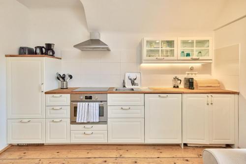a kitchen with white cabinets and a stove top oven at Landhaus Blauer Spatz Reichenau an der Rax in Reichenau
