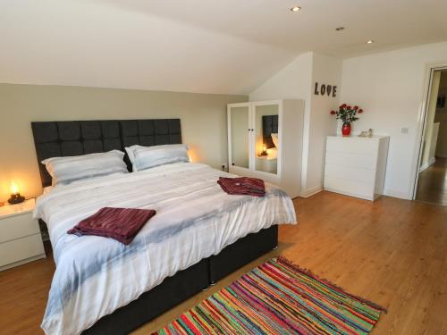 um quarto grande com uma cama grande e um tapete em The Loft at the Lake em Littleborough