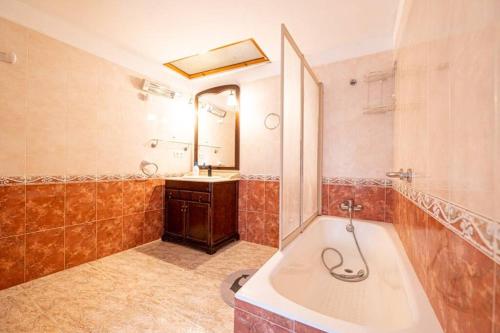 a bathroom with a tub and a sink and a mirror at C,AN ARTUR in Binissalem