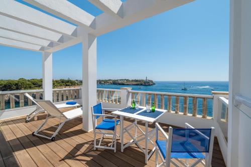 a balcony with a table and chairs and the ocean at Orange Colom - Seaside Apartments in Portocolom