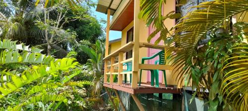een gebouw met een balkon met bomen en planten bij Cabañas Tico Gringo in Drake