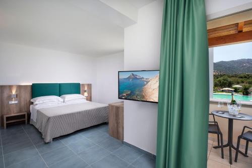 a hotel room with a bed and a television at Hotel San Teodoro in San Teodoro
