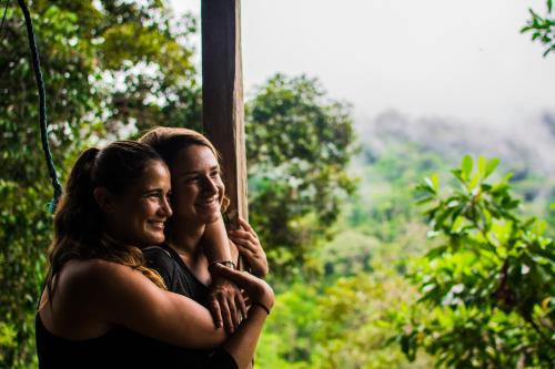 two women hugging each other in front of a window at Wisdom Forest Lodge in Tena