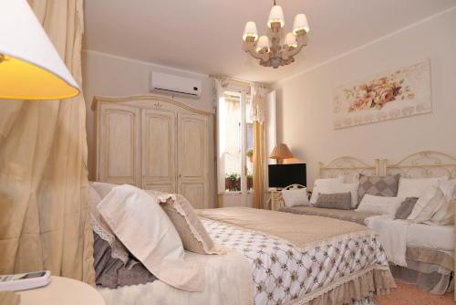 a bedroom with a bed and a couch and a chandelier at Vacanze Romantiche a Modica in Modica