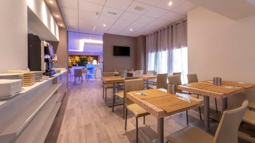 a restaurant with wooden tables and chairs and a counter at Hotel San Marco in Reggio Emilia