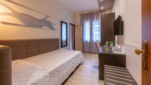 a bedroom with a bed and a desk and a television at Hotel San Marco in Reggio Emilia
