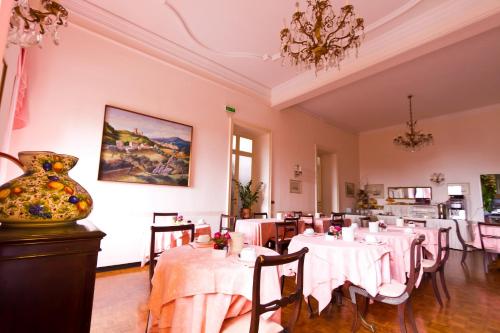 a dining room with white tables and a vase at Hotel La Vela-Castello Il Rifugio in Santa Margherita Ligure