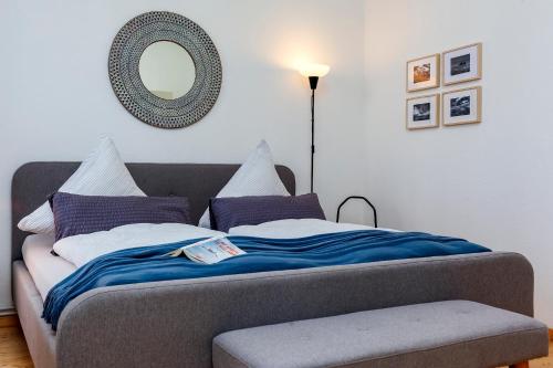 a bed with a blue blanket and a mirror at Haus Borkumitte Appartement Hooge Hörn in Borkum