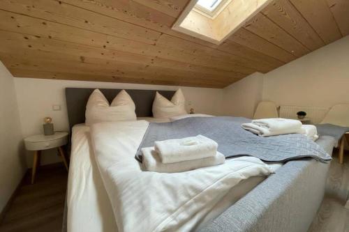 1 dormitorio con 1 cama grande y toallas. en Gemütliche Ferienwohnung im DG am Tegernsee - Bergblick, Ruhe & ganz viel Platz, en Bad Wiessee