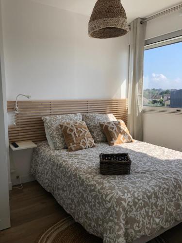 a bedroom with a bed with a large window at Le 84 in Courseulles-sur-Mer