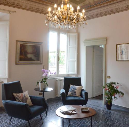 - un salon avec des chaises et un lustre dans l'établissement Le Muse, à Pise