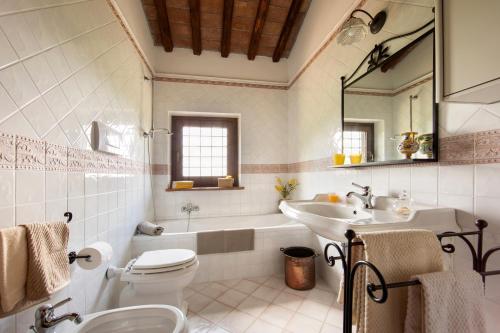 a bathroom with a tub and a sink and a toilet at Casale Eclissi in Bagnaia
