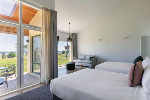 a hotel room with two beds and a balcony at Rydges Formosa Auckland Golf Resort in Auckland