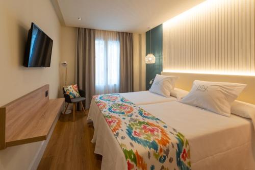 um quarto de hotel com uma cama e uma televisão de ecrã plano em La Puerta de Nerja BOUTIQUE - Adults Recommended em Nerja