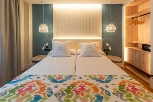 a bedroom with a large bed with two pillows at La Puerta de Nerja BOUTIQUE - Adults Recommended in Nerja