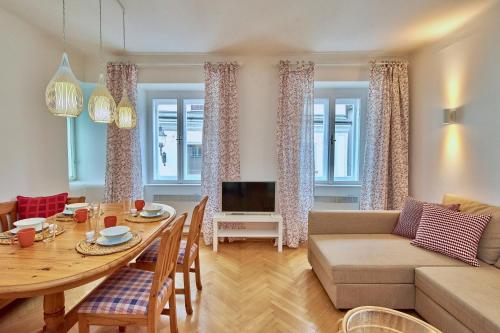 a living room with a table and a couch at Altstadt Apartments Melk mit Sauna in Melk