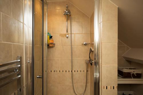 a shower with a glass door in a bathroom at Turks Hall in Bruton