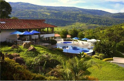 a house with a swimming pool and a mountain at Hotel Sierra de la Cruz in Valle de San José
