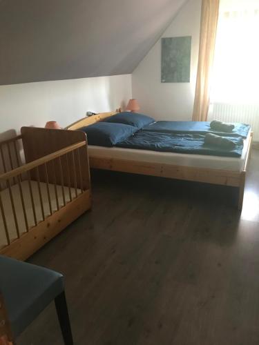 a bedroom with a bed and a crib at Márta Apartman in Balatonalmádi