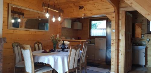 a kitchen and dining room with a table and chairs at Domek letniskowy Michałówka in Łeba