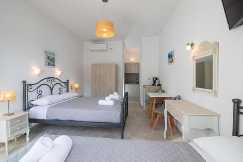 a hotel room with two beds and a desk at KAMARADO STUDIOS in Kamarai