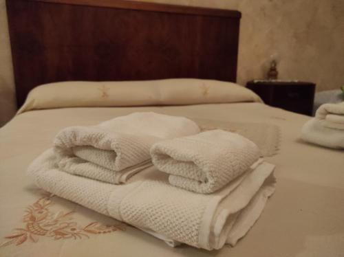 einen Stapel Handtücher auf dem Bett in der Unterkunft Casa "Albero Verde" in Raffo