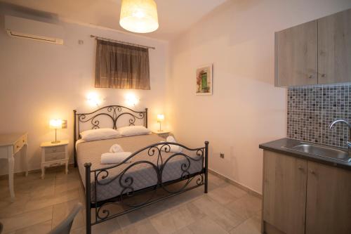 a small bedroom with a bed and a sink at KAMARADO STUDIOS in Kamarai