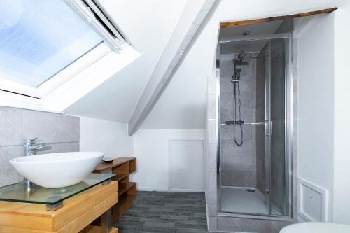 uma casa de banho com um lavatório e um chuveiro em Montague House Apartments em Llandudno